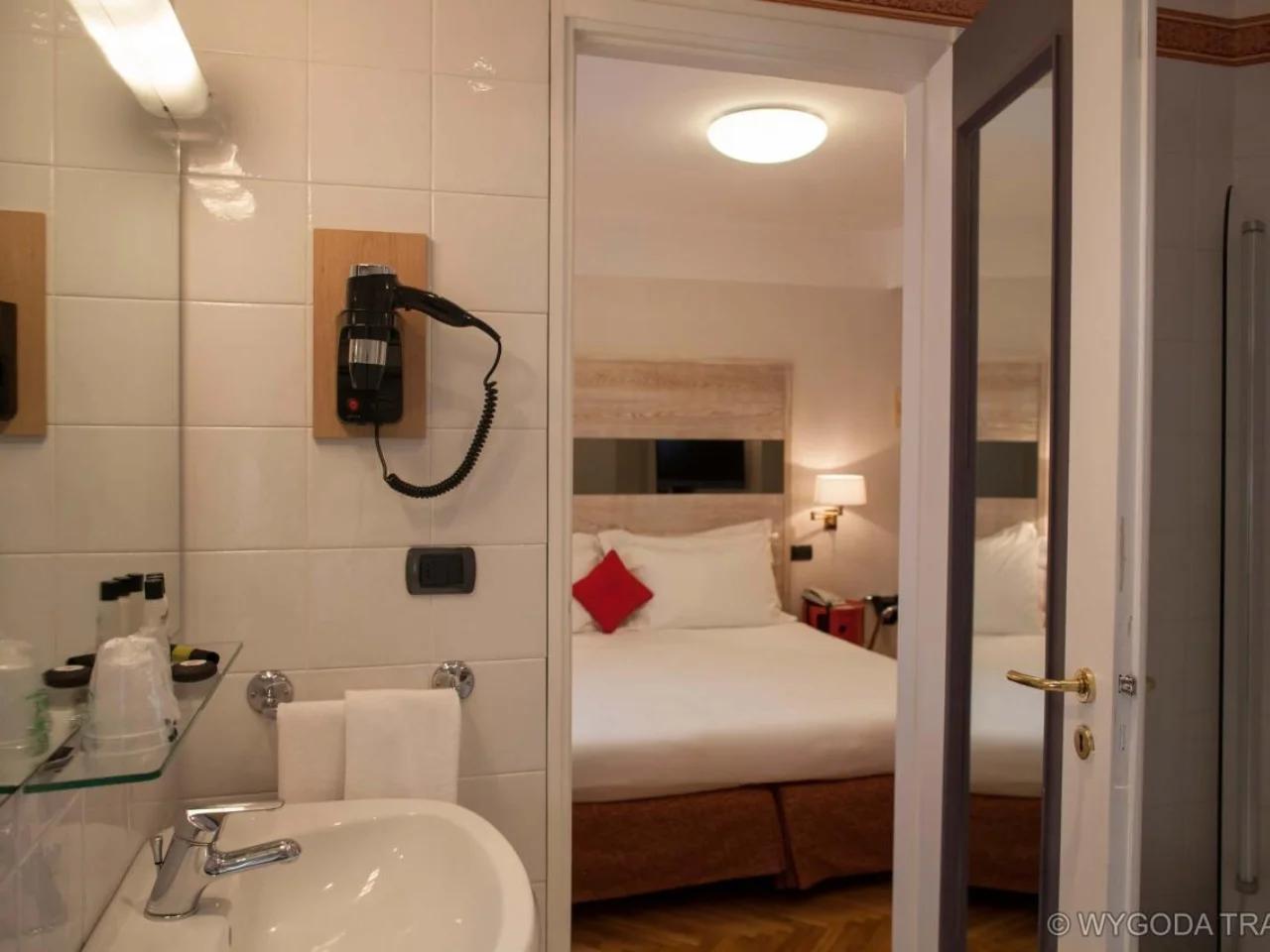 łazienka z umywalką i lustrem w Hotelu ALLA POSTA