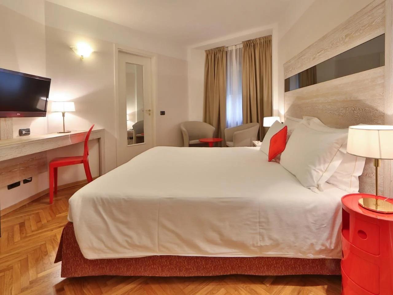 sypialnia z łóżkiem i biurkiem w Hotelu ALLA POSTA