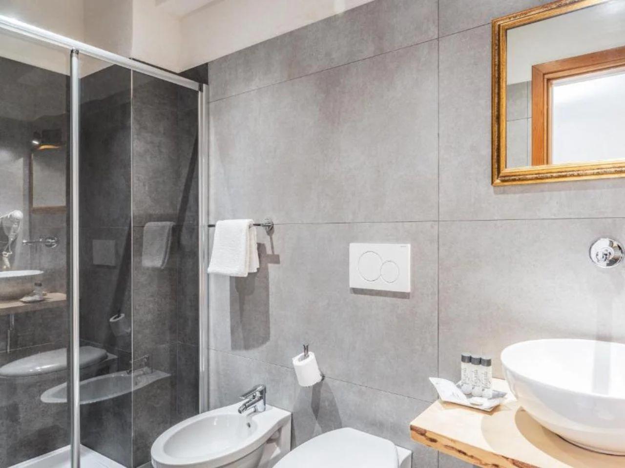 łazienka z prysznicem i umywalką w FOLGARIDA HOTEL