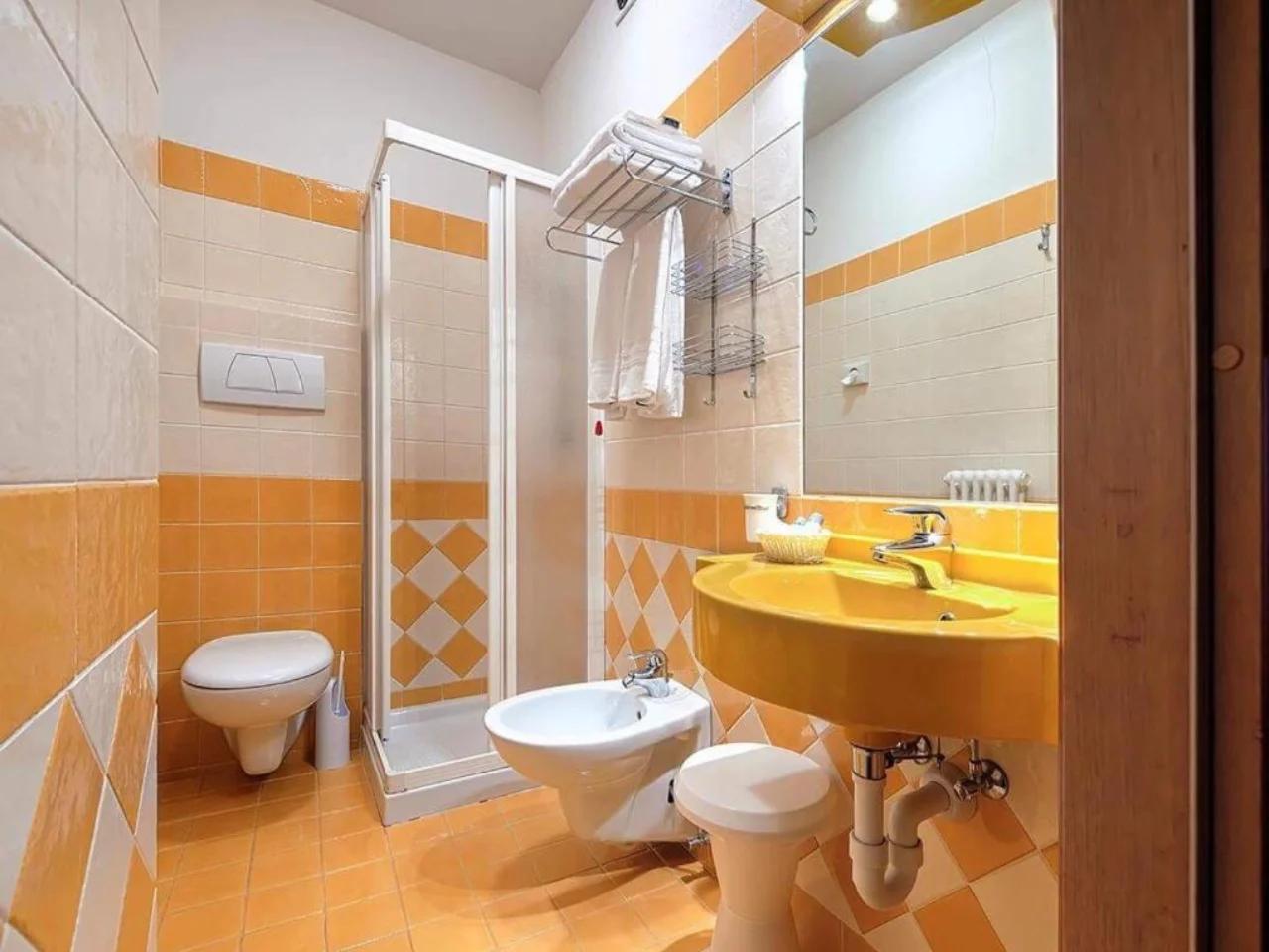 łazienka z umywalką, toaletą i toaletą w FOLGARIDA HOTEL
