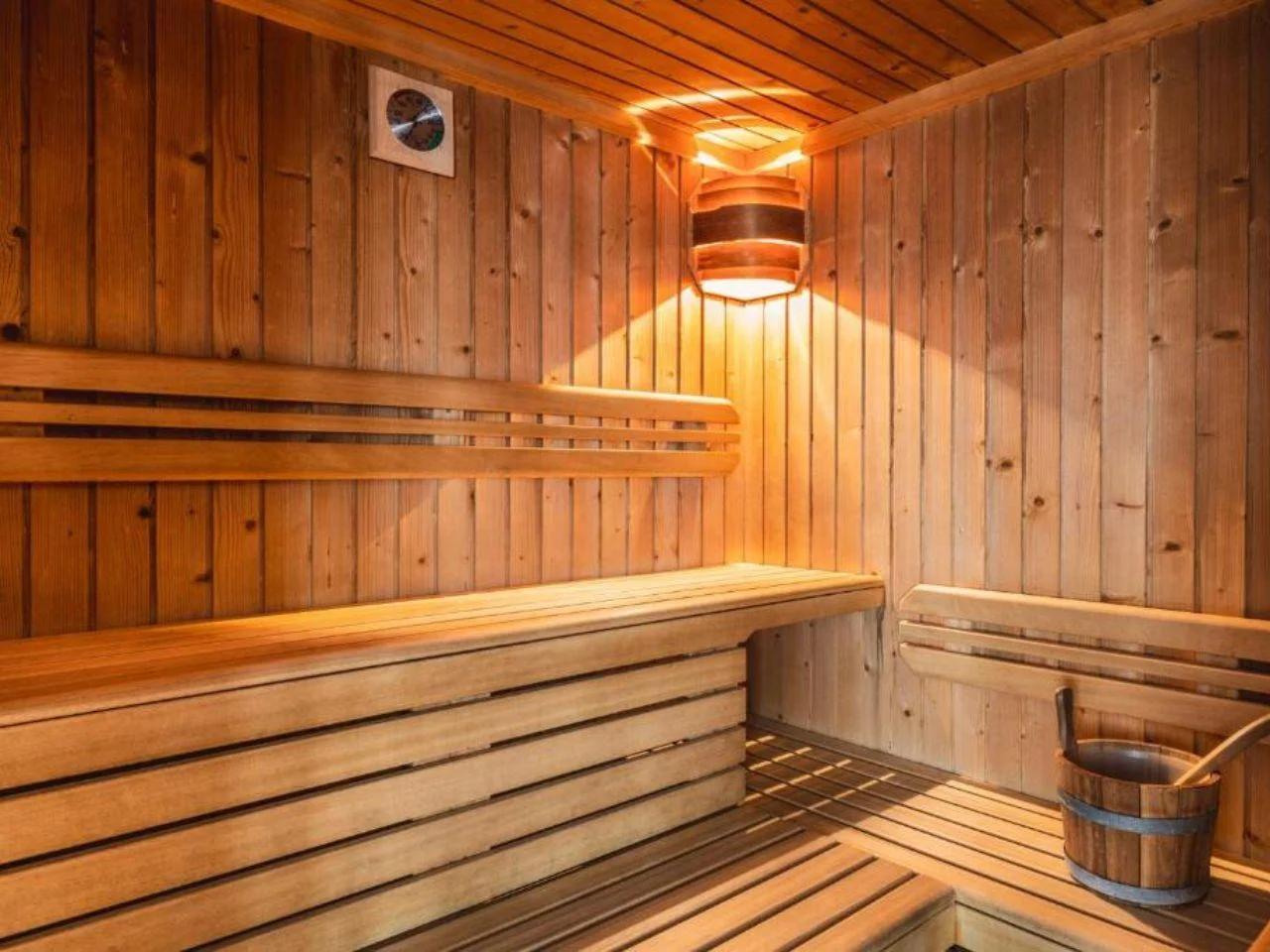drewniana sauna z wiadrem i wiadrem w FOLGARIDA HOTEL