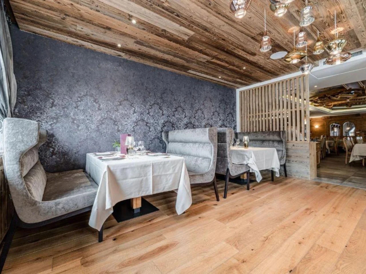 Elegancka część restauracyjna z komfortowymi lożami, drewnianymi wykończeniami oraz kameralną atmosferą sprzyjającą spokojnym posiłkom.