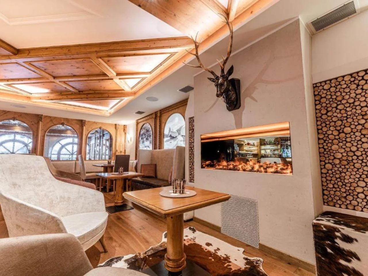Hotelowy lounge z kominkiem, wygodnymi fotelami oraz przytulnym wystrojem w alpejskim stylu.