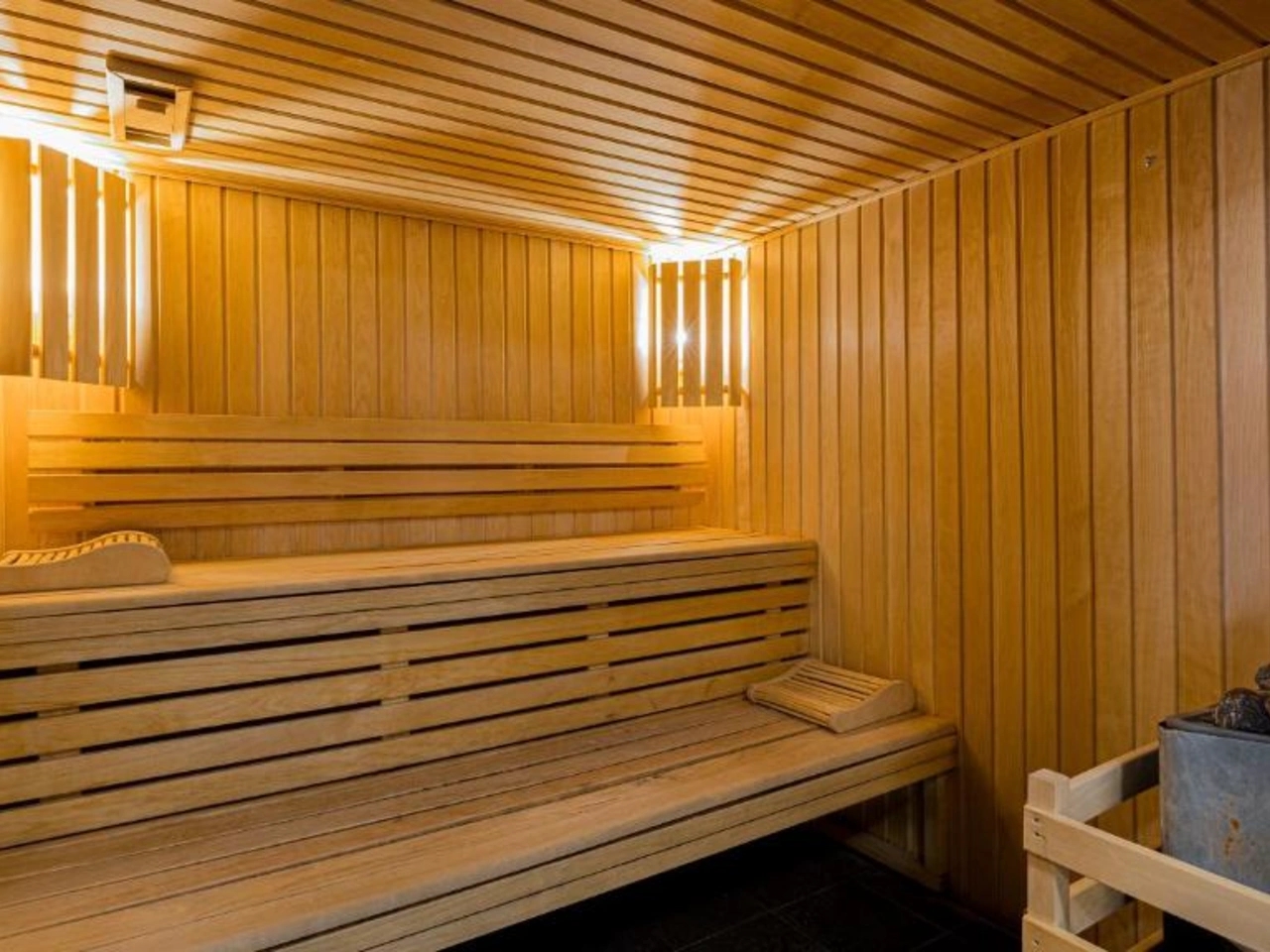 Drewniana sauna z ławkami i piecem na kamienie w La Cascade, Alpe d'Huez, Francja. Idealna do relaksu w Alpach.