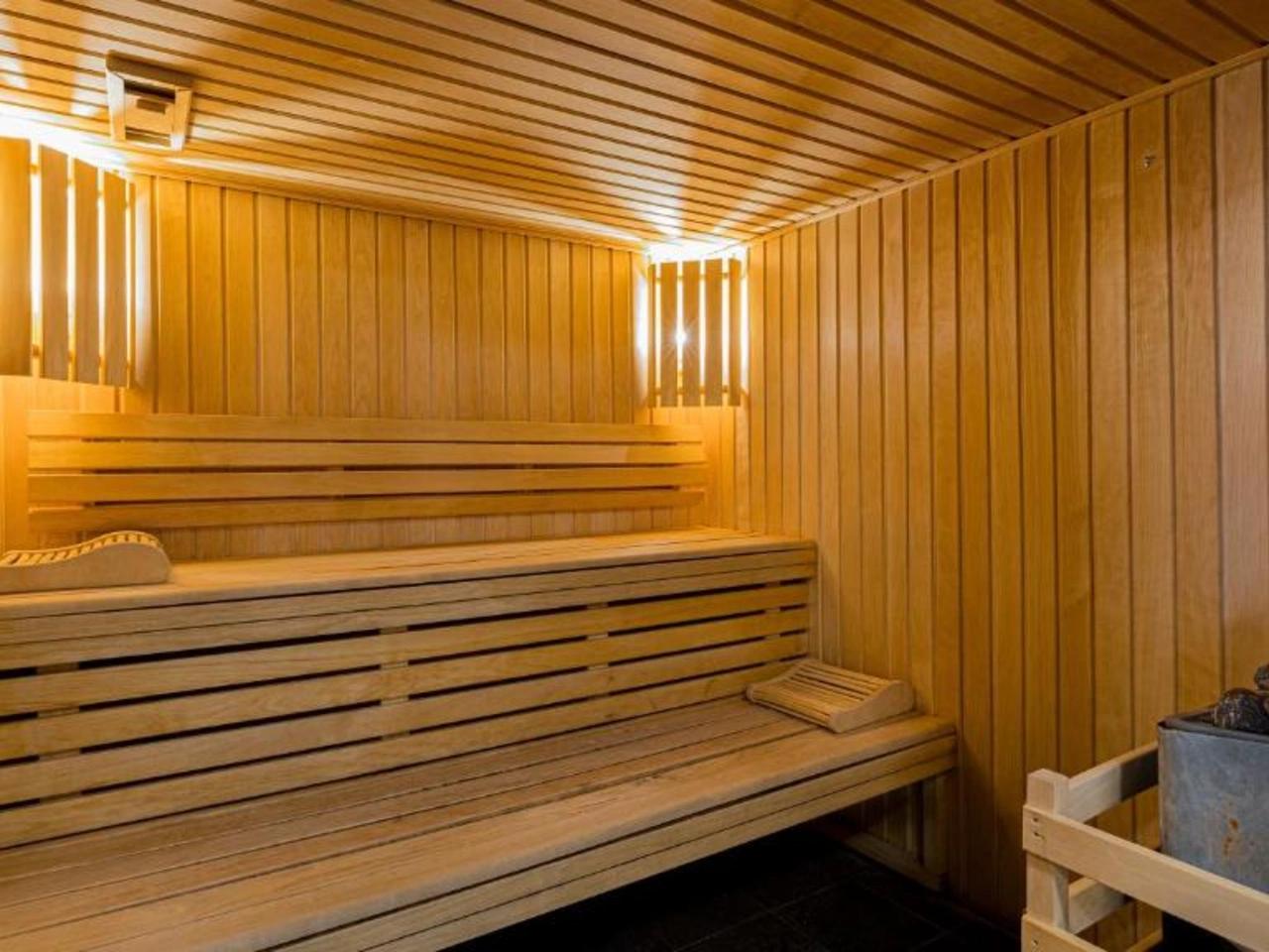 Drewniana sauna z ławkami i piecem na kamienie w La Cascade, Alpe d'Huez, Francja. Idealna do relaksu w Alpach.