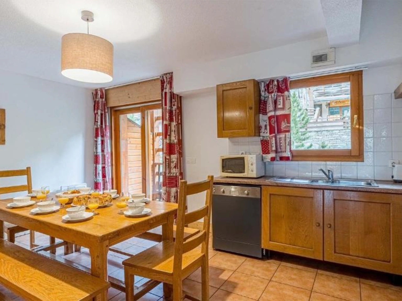 Przytulna jadalnia i kuchnia w apartamencie La Cascade, Alpe D'Huez. Drewniany stół, śniadanie, zmywarka.
