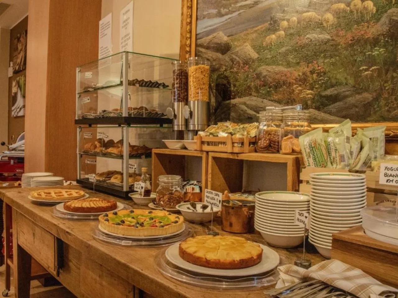 Urozmaicony bufet śniadaniowy w hotelu: ciasta, świeże pieczywo, płatki i dżemy. Idealne na dobry początek dnia.