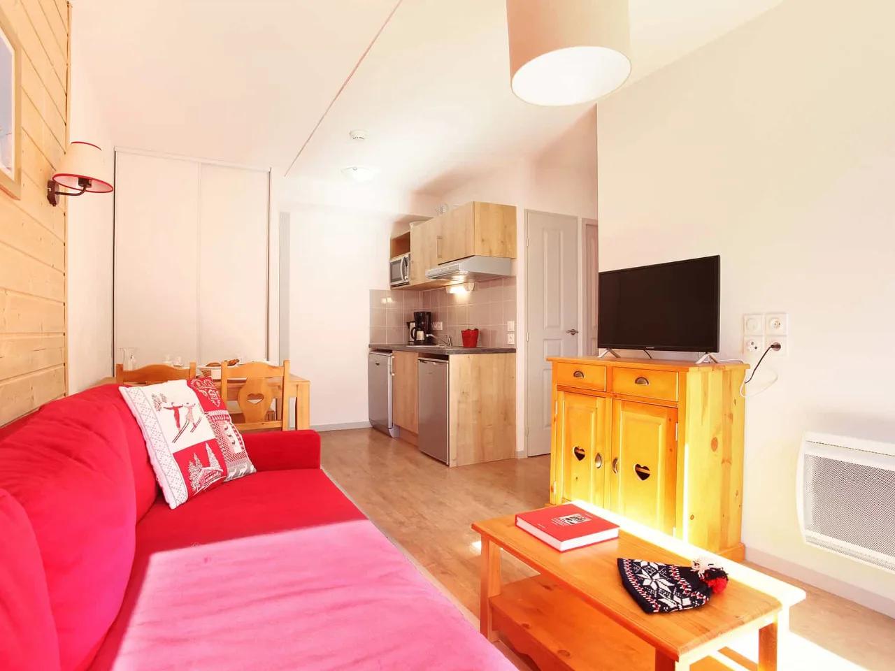 Przytulny apartament typu studio w Le Crystal, Alpe D'huez, z salonem, aneksem kuchennym i drewnianymi akcentami.