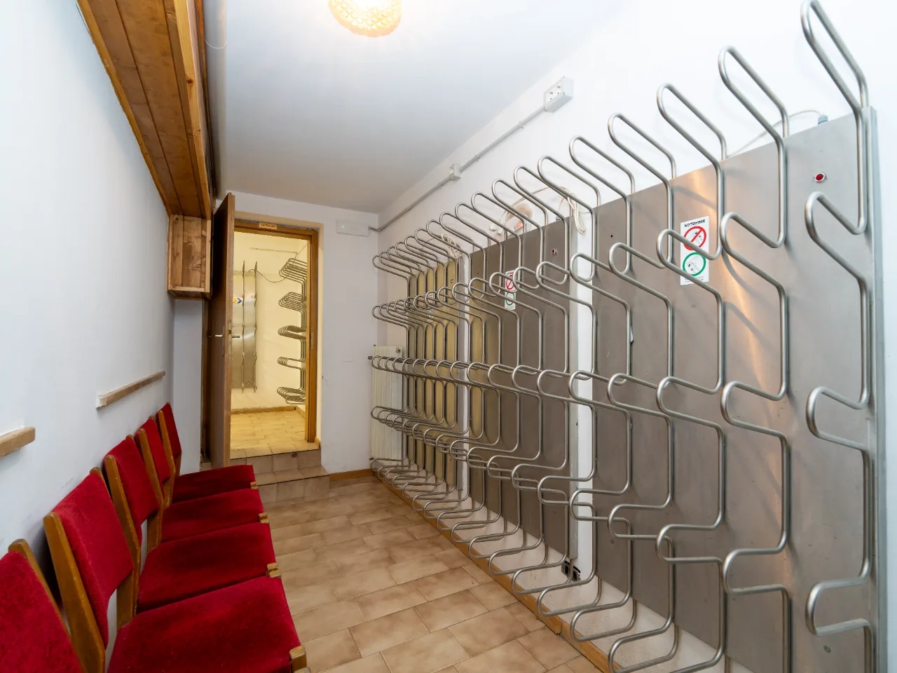 rząd czerwonych krzeseł w korytarzu w DOLOMITES INN DLA - Grupy J. Szmigielski